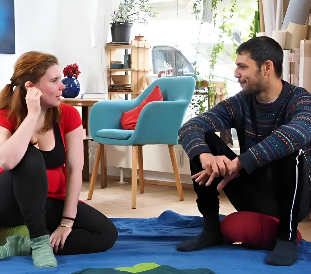 Coach und Klientin sitzen sich im Gespräch gegenüber, körperorientiertes Coaching in Berlin und online