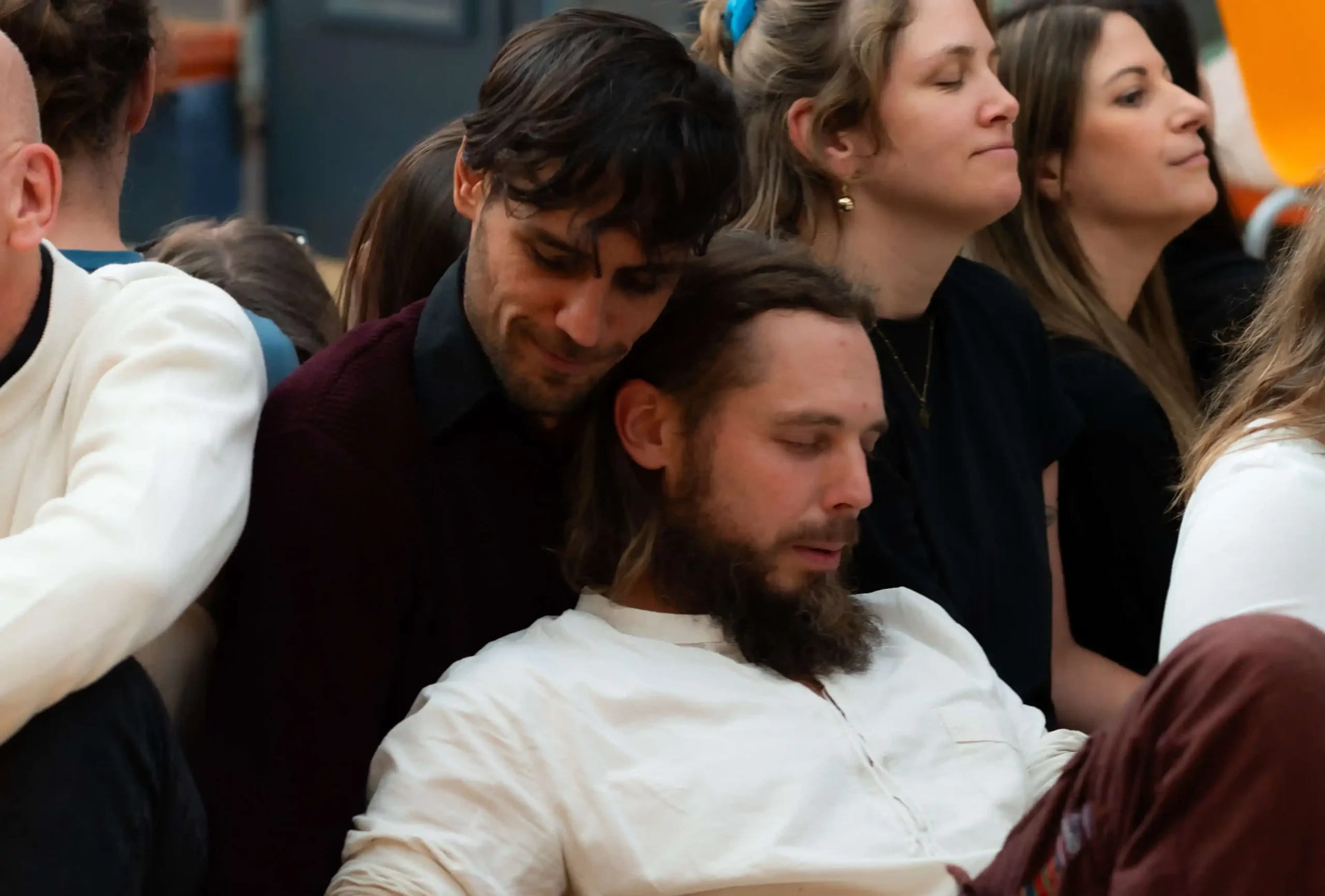 Benjamin Malik gibt einem Teilnehmer im Workshop Rückhalt und Unterstützung durch achtsame Umarmung